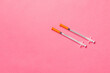 Top view of two insulin syringe at colorful background with copy space. High level of glucose concept