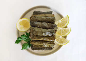 Traditional oriental Turkish dolma made of grape leaves stuffed with rice on a decorative plate