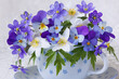 Bouquet of spring blue hepatica flowers, anemones, pansies, violets in a cup on a white background, closeup, beautiful card