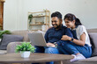 © itchaznong - Happy indian Couple Using Laptop Browsing Internet Together on sofa at home