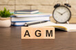 the wooden blocks forming the word AGM - Annual General Meeting concept