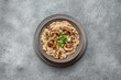 Risotto with brown champignons in a plate on a gray rustic background. View from above.