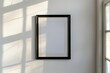 Ein leerer schwarzer Bilderrahmen an einer weißen Wand, Rahmen Mockup 