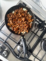 Wall Mural - Fried chanterelles with onions in a frying pan