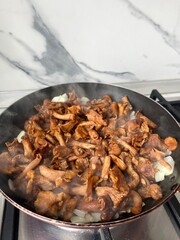 Wall Mural - Fried chanterelles with onions in a frying pan