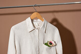 Fototapeta  - Linen shirt hanging on wooden hanger close up