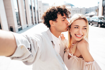 Sticker - Young smiling beautiful woman and her handsome boyfriend in casual summer clothes. Happy cheerful family. Female having fun. Couple posing in the street background at sunny day. Take selfie