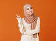 beautiful young smiling muslim woman in traditional religious hijab shows finger up.