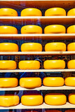 Fototapeta Uliczki - yellow cheese wheel as decoration in the shop window
