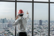 © Jack Tamrong - Back view engineer man standing and looking out of high rise office windows
