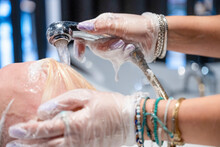 Hairdresser Rinsing Client's Hair At A Salon