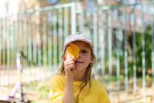 Girl With A Yellow Leaf Covering One Eye