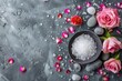 A bowl of sea salt next to pink roses and stones. Perfect for spa and wellness concepts
