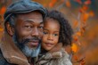 Gentle portrait of an older man with a beard cuddling a young girl, amidst orange autumn leaves