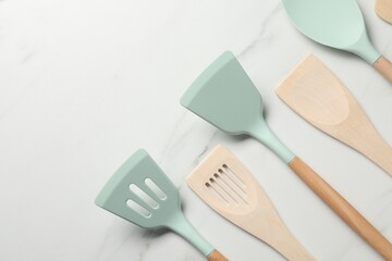 Sticker - Different spatulas on white marble table, flat lay. Space for text