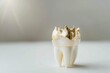 Dental crown on white surface with bright light in background, close up of tooth with gold cap