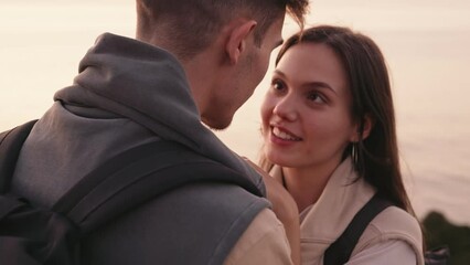 affectionate young couple in a loving embrace, enjoying a serene sunset on the beach, radiating roma