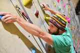 Fototapeta  - young sporty man bouldering in a climbing hall - indoor sports