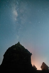 Wall Mural - Sleman, Indonesia - July 14,  2015. Milky Way galaxy stretches in the sky Sleman with the foreground silhouette of the ijo temple