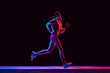 © master1305 - Athletics young woman with slim, fit body in sportswear and headphones running on black studio background with pink neon. Concept of active and healthy lifestyle, sport, hobby, motivation, endurance