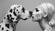 Woman with dalmatian pattern makeup nose to nose with a Dalmatian dog