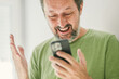 Happy man received satisfying text message on mobile smartphone