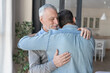 Loving cute old elderly senior father hugging embracing his young adult son showing him love and support. Family time, happy father`s day! I love you, dad!