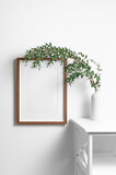 Fototapeta Lawenda - Vertical wooden frame mockup on white wall with natural eucalyptus twigs, copy space