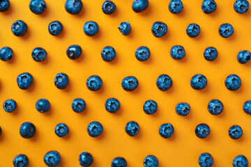 Wall Mural - Pattern of Fresh Blueberries on Vibrant Orange Background with Copy Space