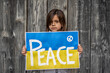 Solemn child's plea for peace amidst conflict. A heartfelt call for global ceasefire and unity.