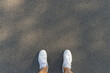Fitness and healthy lifestyle concept. Man looking running sneakers on a asphalt road. Top view and copy space