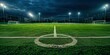 A photo of an empty soccer field, green grass, night time, lights on the side of the pitch, center circle marked with white lines, dark sky.