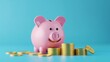 © Bijac - smiling pink piggy bank with stack of gold coins on blue background 3d rendering