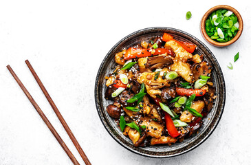 Wall Mural - Hot stir fry chicken  slices with red paprika, mushrooms, chives and sesame seeds with ginger, garlic and soy sauce. White table background, top view