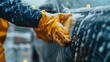 closeup male hands in rubber gloves of a car wash worker polishing a car body with sponge