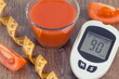 Glucometer with sugar level, tape measure and tomato juice. Healthy lifestyle and nutrition during diabetes