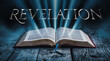 The book of Revelation. Open bible with blue glowing rays of light. On a wood surface and dark background. Related to this book: Apocalyptic, Prophecy, Vision, Revelation, End Times, Judgment, end
