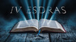 The book of 4 Esdras. Open bible with blue glowing rays of light. On a wood surface and dark background. Related to this book: Apocalyptic, Prophecy, Vision, Exile, Judgment, Hope, Interpretation