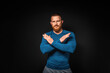 Athletic muscular man posing on a black background, crossed hands. Copy space. Concept of prohibition