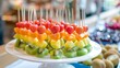 Colorful rainbow colors fruit kebab sticks served in a plate on rainbow theme birthday party
