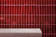 edge of grey slate stone counter with blank space for product montage display with red ceramic tiles at background. border of stone table for decoration in vintage style. front view of table.