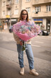 Cheerful girl in white sneakers and jeans with a bouquet of beautiful flowers