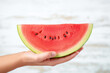 Hand holding a juicy watermelon slice: A quintessential symbol of summer, bursting with sweetness and hydration, perfect for refreshing snacks and desserts.