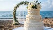Wedding cake at a beach wedding on the background of a beautiful arch for an exit ceremony
