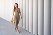 Elegant woman in fashionable dress smiling on minimalist background