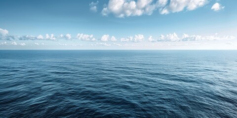 Wall Mural - The ocean is calm and clear, with a few clouds in the sky. The water is a deep blue color, and the sky is a bright blue color. The scene is peaceful and serene