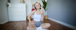 Portrait of happy, fit and healthy young woman sitting on yoga mat, wearing wireless headphones, showing thumbs up with satisfied face, pleased with workout training at home
