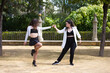 Couple of young women dancing to latin music: Bachata, merengue, salsa. The two girls do different postures dancing outdoors in the street. Latin dances and dance concept.