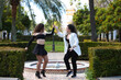 Couple of young women dancing to different types of Latin music and dance. The two girls do different postures dancing outdoors in the street. Latin dances and dance concept.