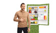 Man holding his hand on his stomach and standing in front of a sustainable refrigerator